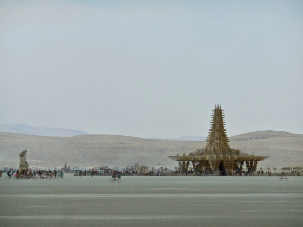The figure to the left is a mobile art piece. She roamed the playa, dressed differently each day. She also attracted an entourage of bike riders.